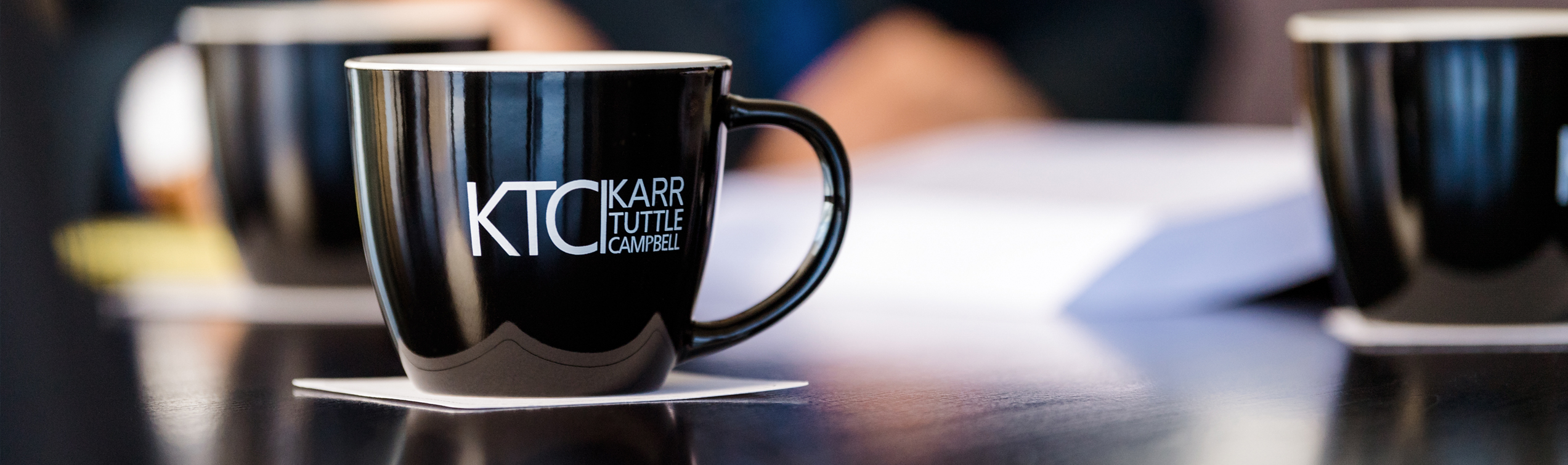 Table with coffee cups displaying KTC logo.